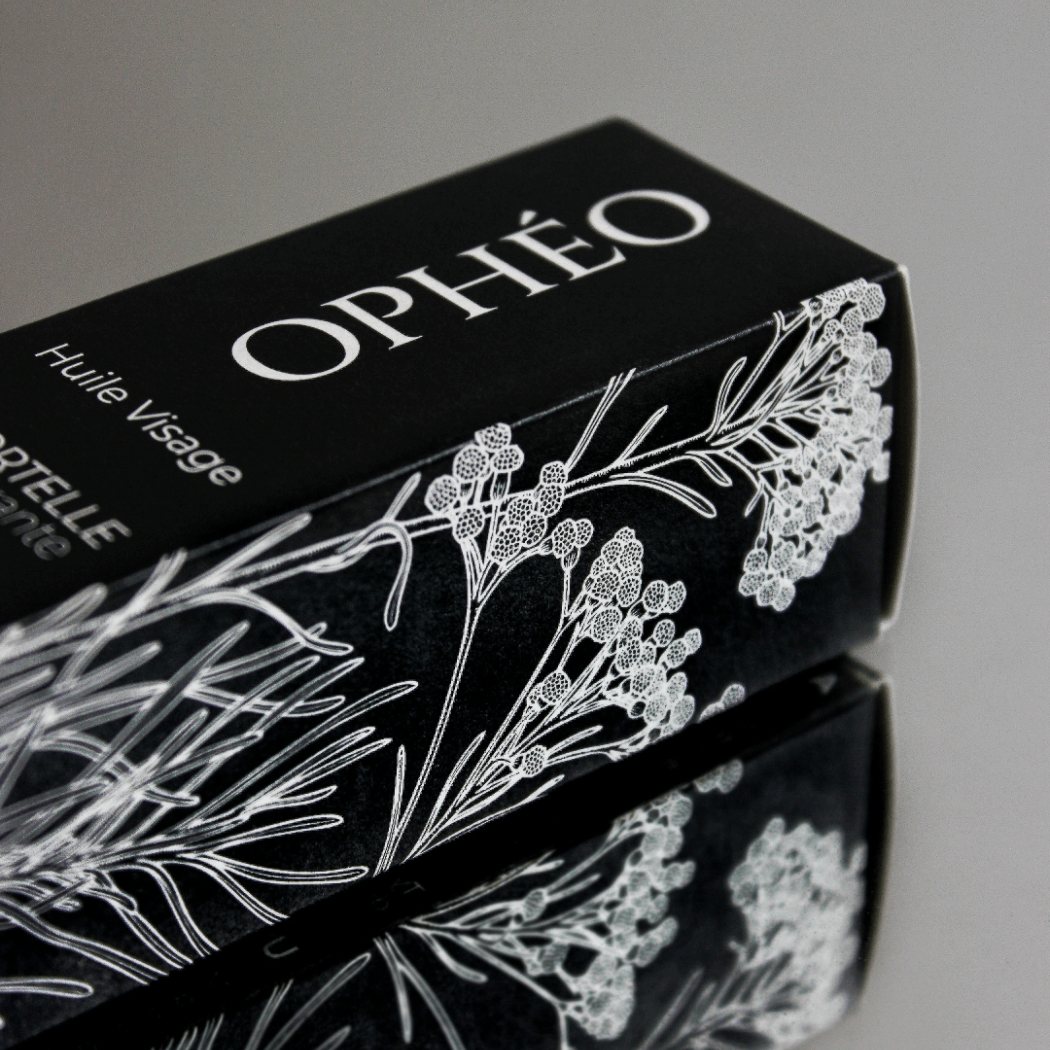 Emballage carton de l'Huile Visage Immortelle Régénérante OPHÉO, élégant, noir et blanc avec illustration botanique de l'immortelle corse.