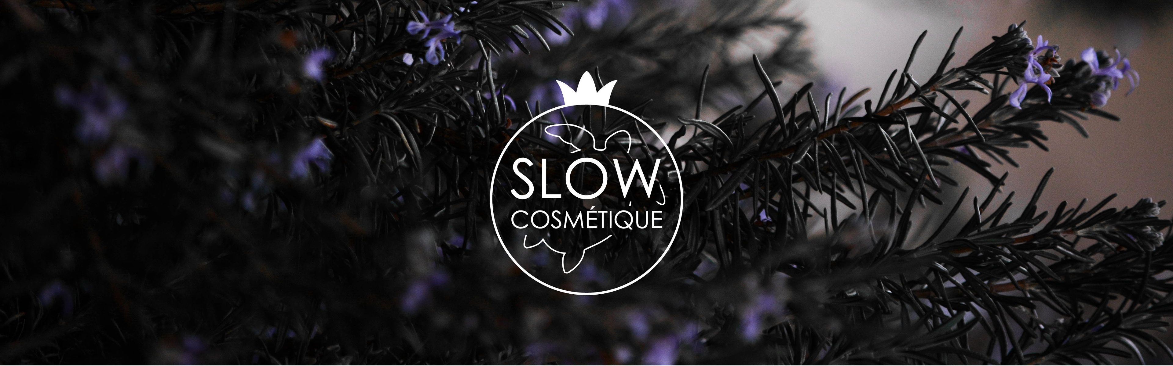 Le logo du label Slow Cosmétique est en premier plan. En arrière plan, une photo de branches de romarin fleurit.