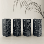 Les quatre huiles visage OPHÉO dans un packaging élégant noir et blanc avec illustrations botaniques.
